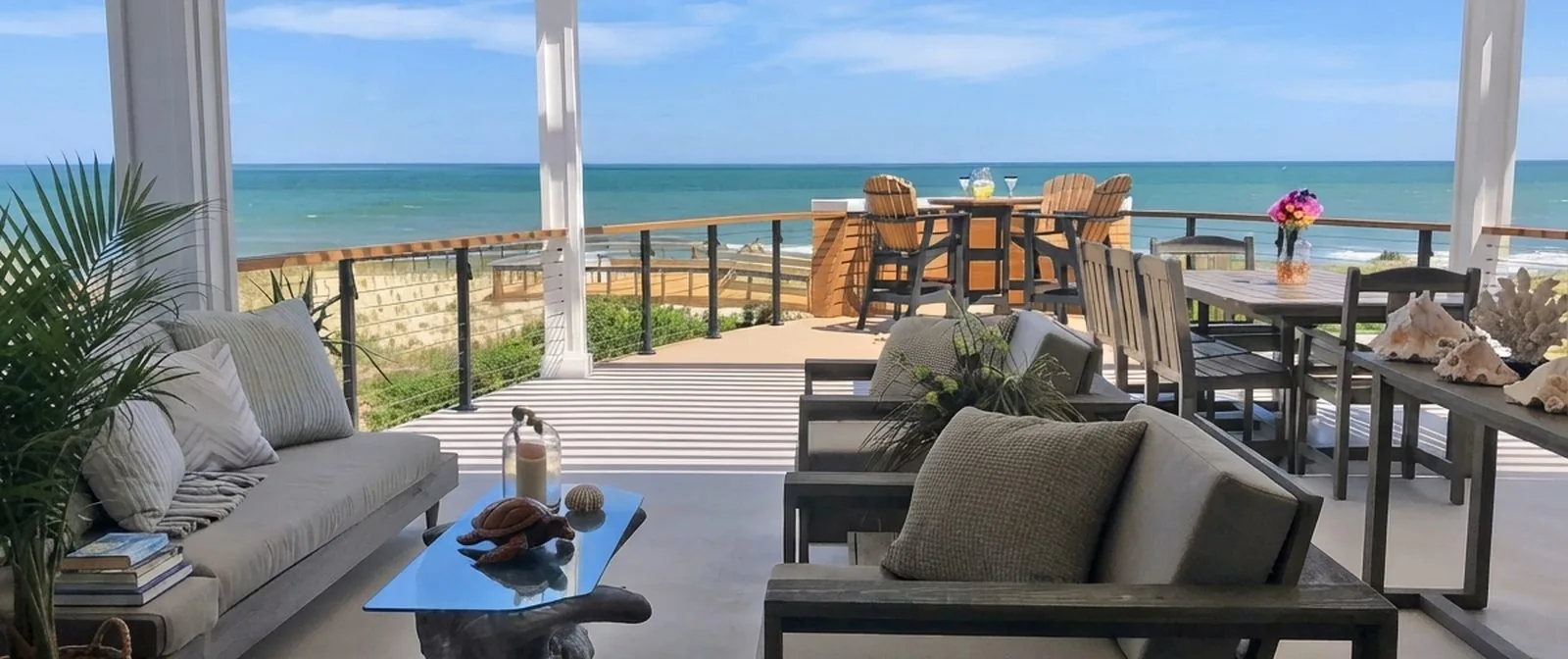 White louvered pergola over a beachfront deck