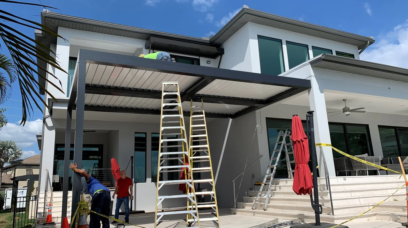A United States Pergola crew setting the louvers on a new pergola over a lanai