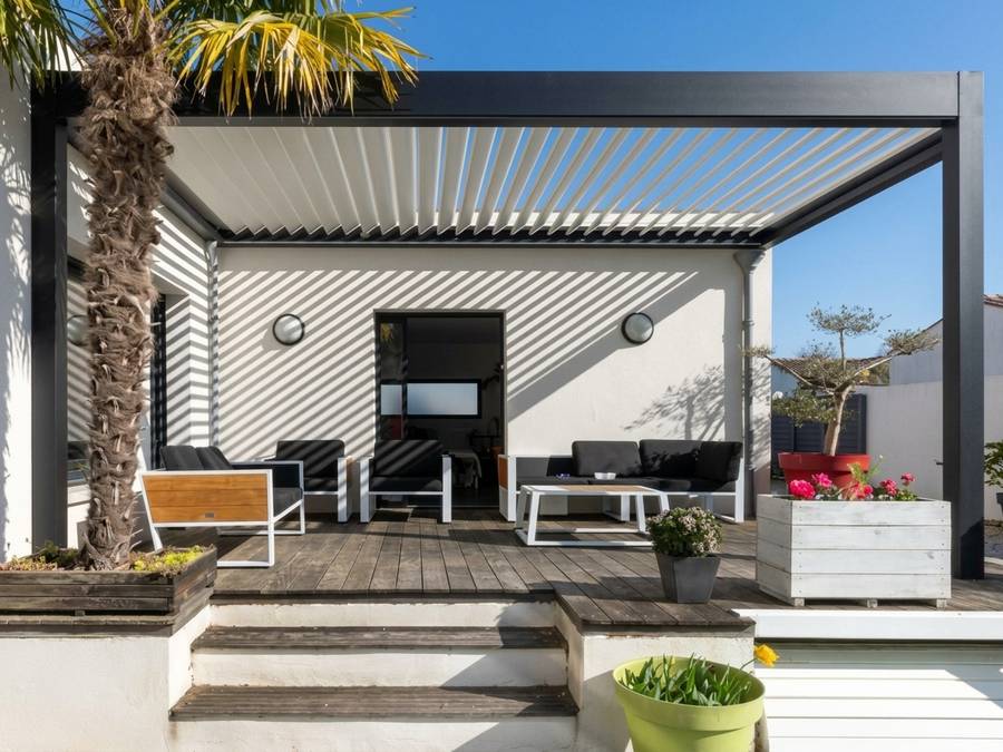 Matte black louvered pergola tucked tight against the wall of a narrow side yard